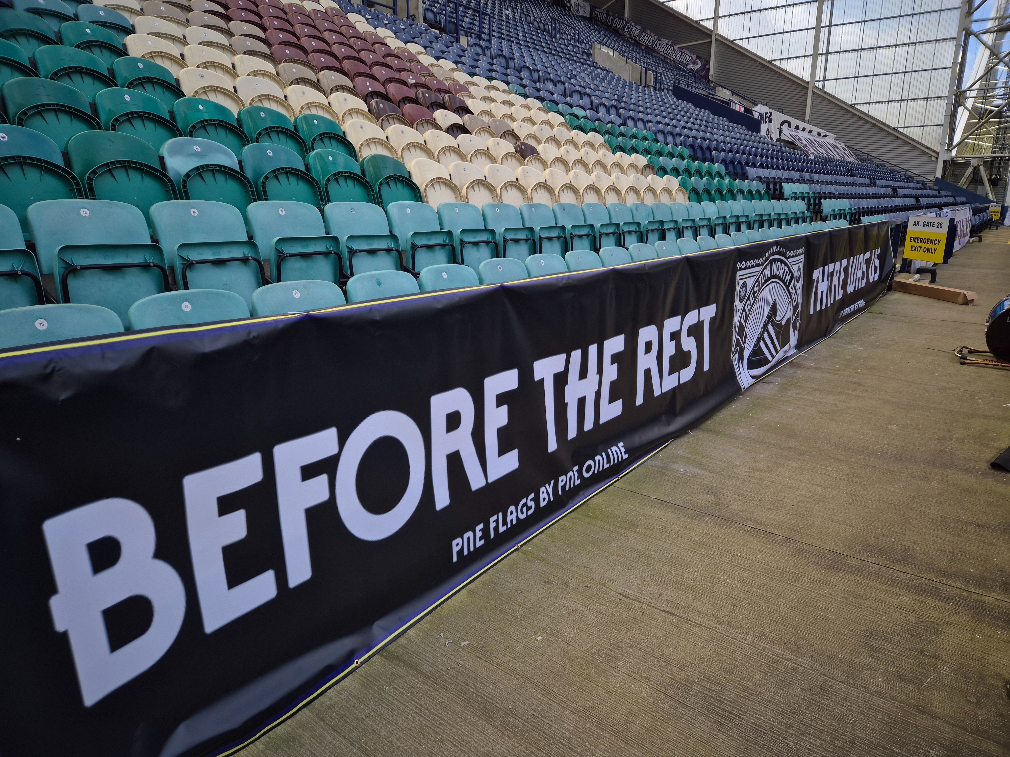 A long PNE Flags banner installed at the front of a stand at Deepdale.